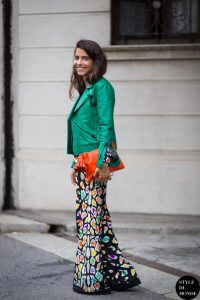 Девушка в длинной цветастой юбке, с яркой оранжевой сумкой и в темно-зеленой куртке