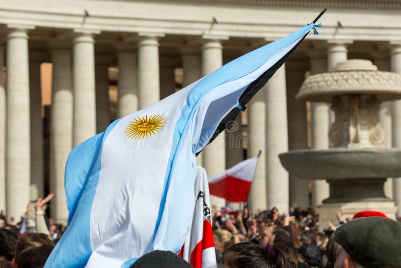 An Argentinian Flag in St, Peter`s Square. Vatican City, Vatican - February 22, 2015: A crowd gathers in St. Peter`s Square while someone waves a Argentinian royalty free stock photography