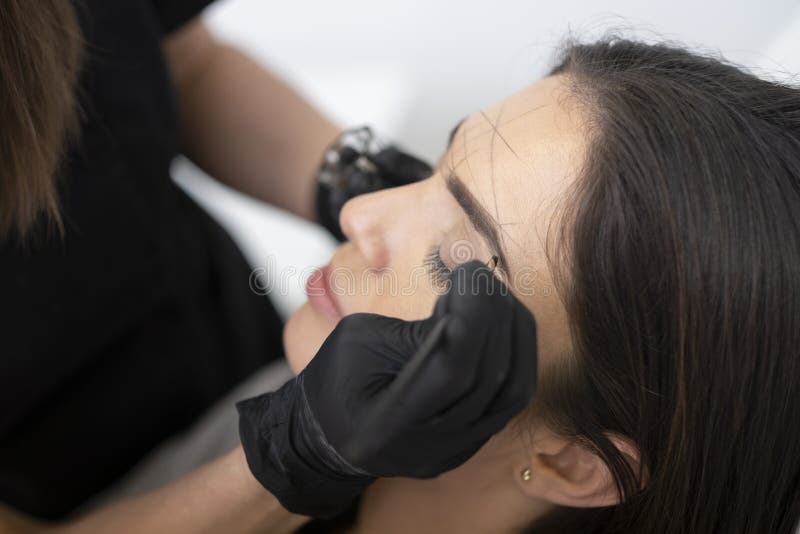 Beautiful woman is doing her eyebrows in the beautician. royalty free stock photo