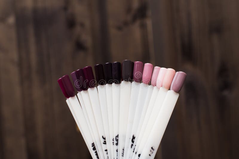 beige palette of nail polishes. Pastel nail tips on a wooden background. stock images