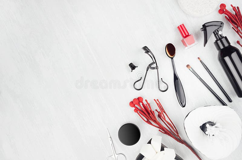 Bright black, silver luxury glossy make up accessories, beauty products, manicure tools with red sprig, silver sequins purse. stock image
