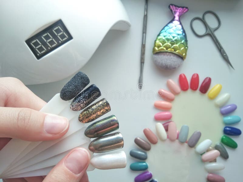 Bright shiny designs on the tips. Color palette. Drawings on nail tips with silver, gold and shiny coating stock photo