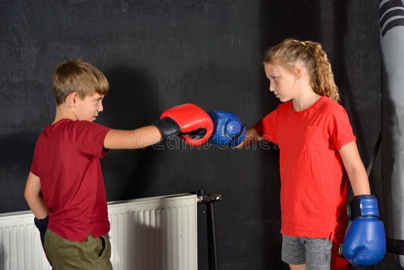 Brother and sister in boxing gloves greet each other by banging their fists. Children are boxing.  royalty free stock photography