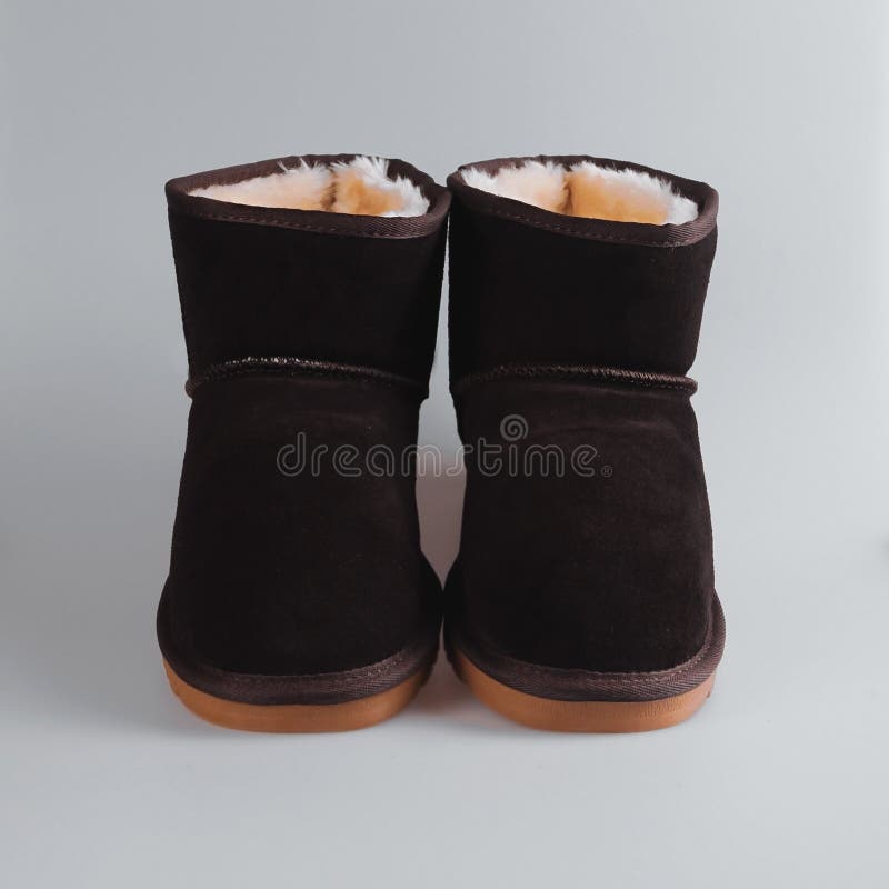 Brown female Fashion winter boots. Over grey stock photo