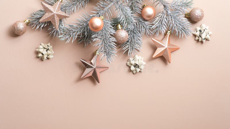 Christmas tree branch with luxury cream color decorations on copper background. Flat lay, top view, copy space. Xmas frame, winter. Holidays banner mockup, New stock photo