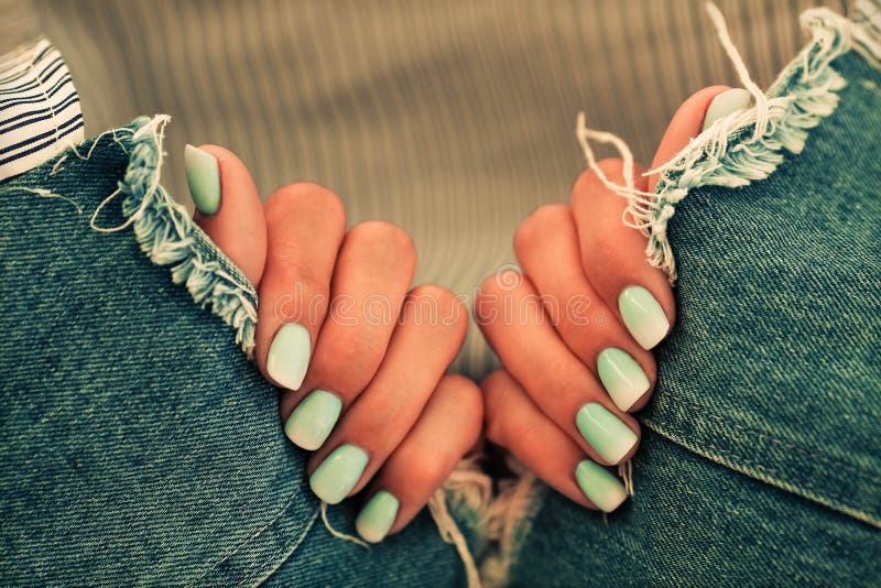 Close up nails with a gradient blue manicure on a jeans background royalty free stock images