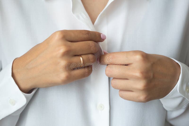 Close-up photo of elegant light pink manicure over white shirt background, tender women`s hands with perfect nails stock photo