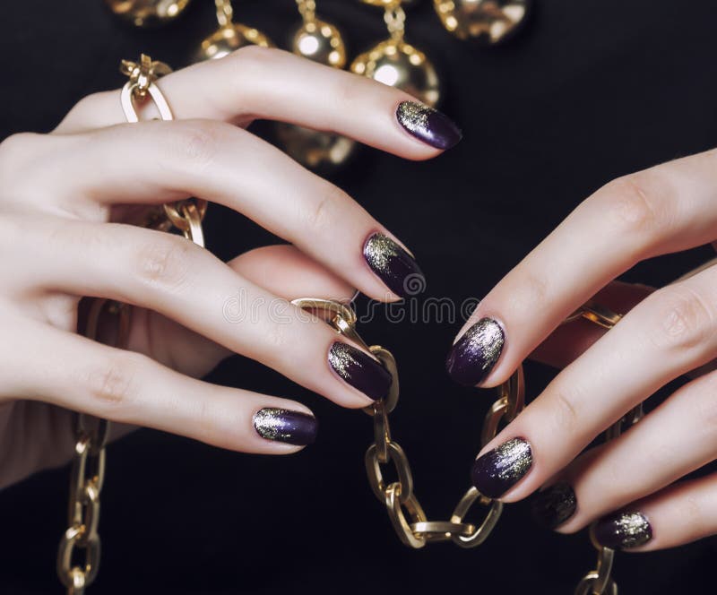 Close up photo hands with gold manicure holding chain on black royalty free stock photos