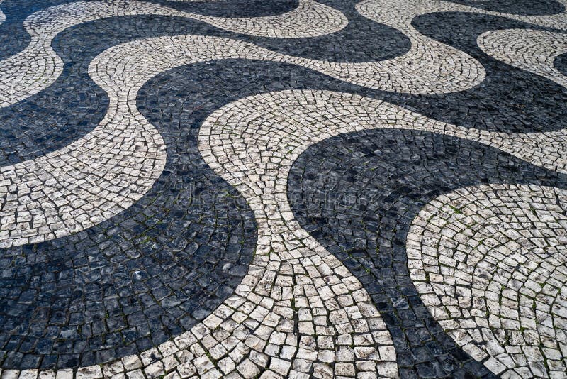 Close up of the waves of tiled cobblestone floor in Portuguese traditional style, at Rossio Square, Baixia Lisbon.  royalty free stock image
