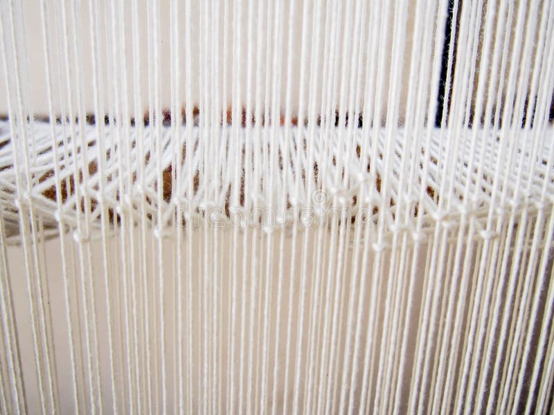 Closeup of Strands of White Yarn on Loom. Many strands of white yarn on a loom make a bright, pleasant pattern stock photography