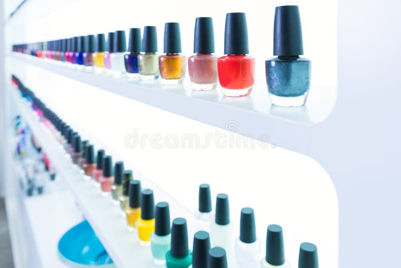 Colorful nail polish colors in a row at nails saloon on white stock photography