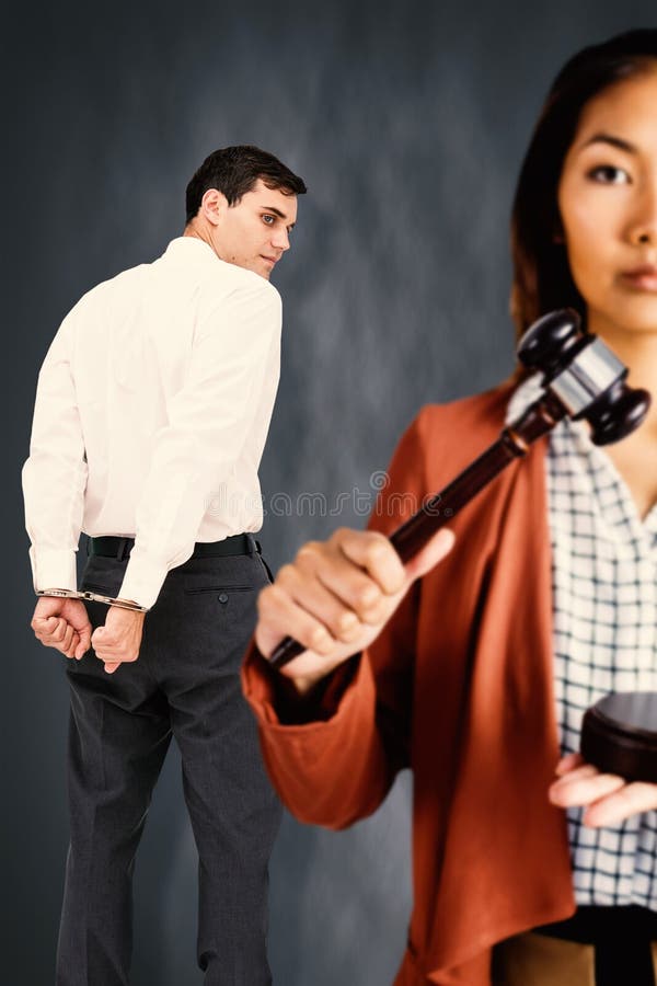 Composite image of businesswoman banging a law hammer on the gavel. Businesswoman banging a law hammer on the gavel against dark background royalty free stock photos