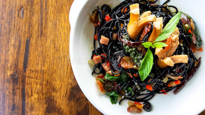 Drunken spaghetti strands Black on white plate. With sausage, chilies, basil stock images