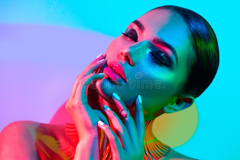 Fashion model woman in colorful bright lights posing in studio royalty free stock photos