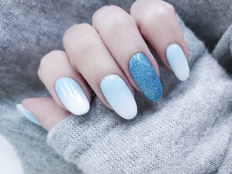 Female hand beautiful fashion blue design stylish ombre acrylic manicure, sweater, winter stock photos