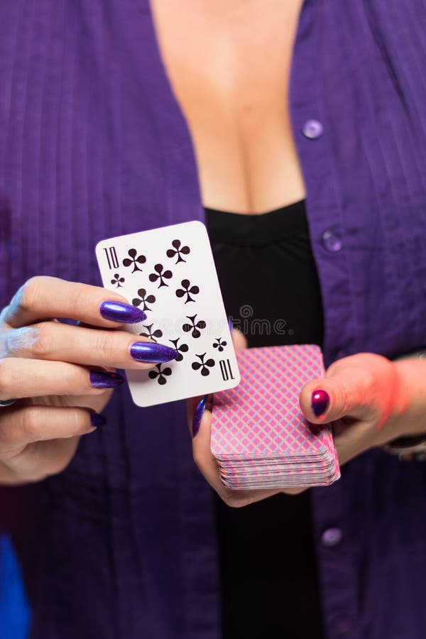 Female hands with a purple manicure hold a deck of play cards royalty free stock photos