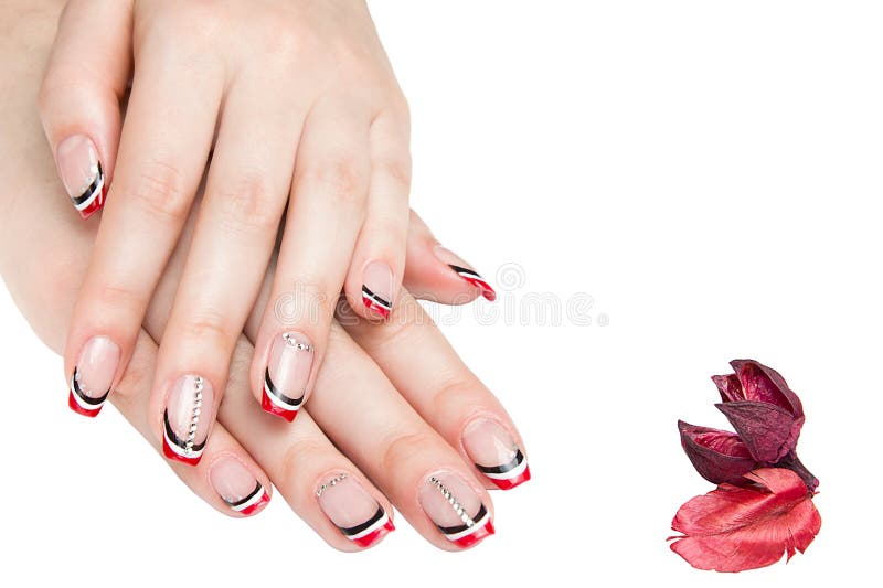 French manicure - beautiful manicured female hands with red black and white manicure with rhinestones isolated on white background stock photography