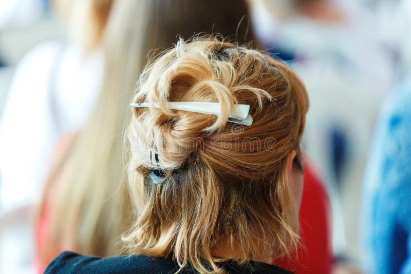 The girl`s dyed short hair is bound with an iron barrette. The girl`s hair back view royalty free stock images