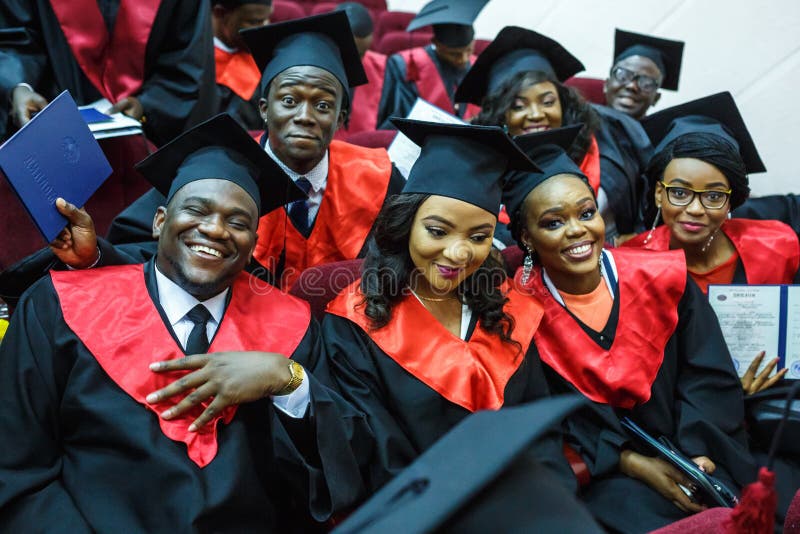 GRODNO, BELARUS - JUNE, 2018: Foreign african medical students in square academic graduation caps and black raincoats during royalty free stock image