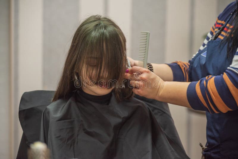 Hair salon concept. Girl bang bang in a beauty salon. A child in the barber cuts his hair stock photo