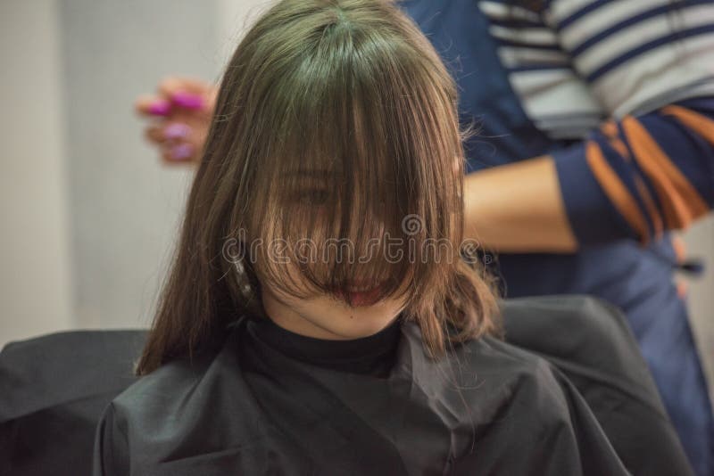 Hair salon concept. Girl bang bang in a beauty salon. A child in the barber cuts his hair stock photos