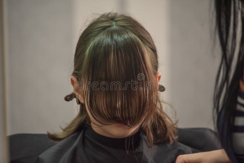 Hair salon concept. Girl bang bang in a beauty salon. A child in the barber cuts his hair stock photography