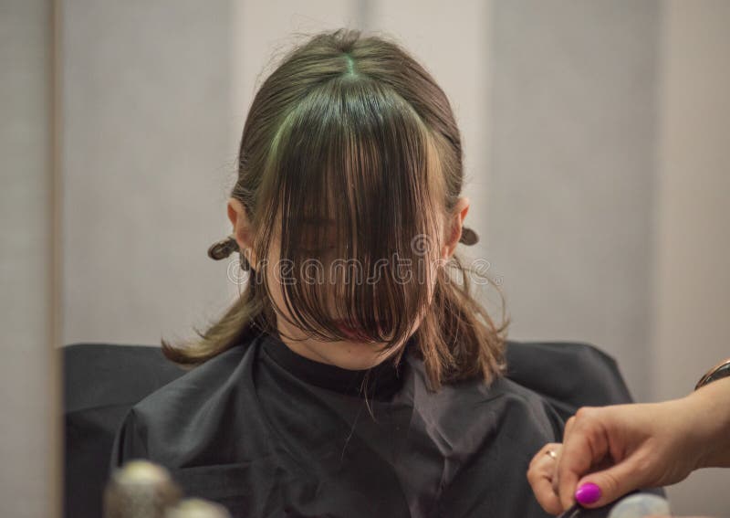 Hair salon concept. Girl bang bang in a beauty salon. A child in the barber cuts his hair stock images