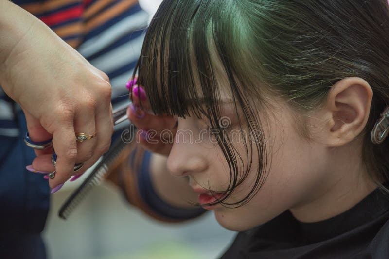 Hair salon concept. Girl bang bang in a beauty salon. A child in the barber cuts his hair stock image