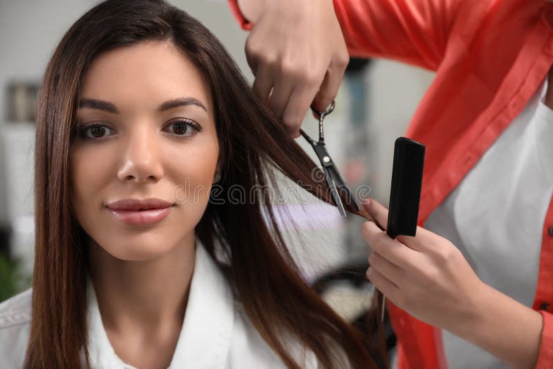 Hairdresser making stylish haircut with scissors in salon. Hairdresser making stylish haircut with professional scissors in salon royalty free stock photo