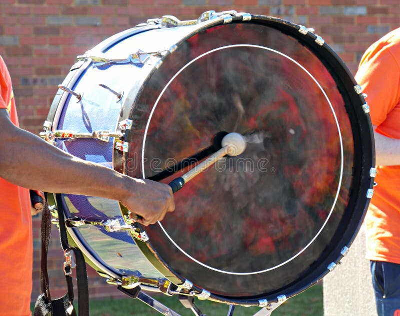Hand of a drummer banging a big drum. At an outdoors performance royalty free stock image