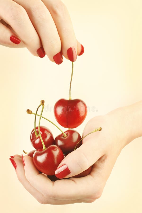 Hands cherry with red nails manicure stock photography