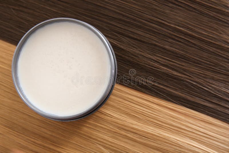 Jar with clay for styling on strands of blonde and brown. Hair royalty free stock photo