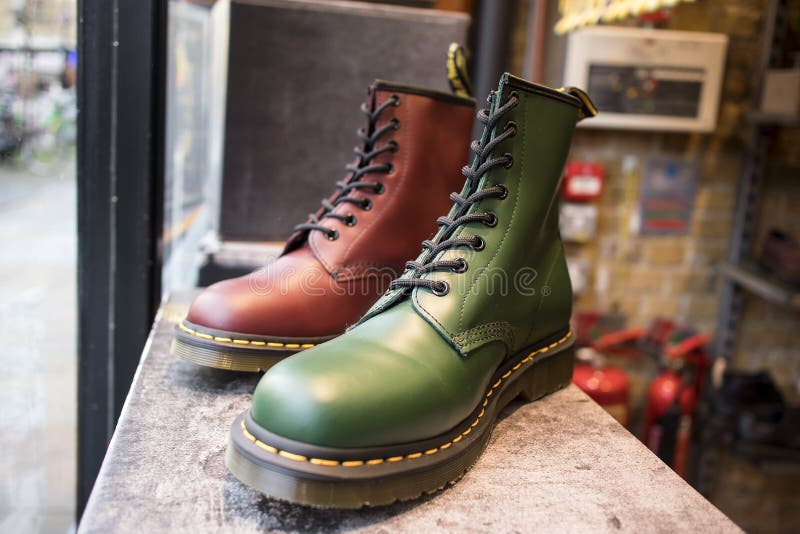 Classic green and burgundy leather Dr. shoes Martens with yellow shoelaces for sale in a shop window stock photo