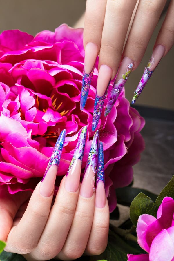 Long beautiful manicure with flowers on female fingers. Nails design. Close-up stock image