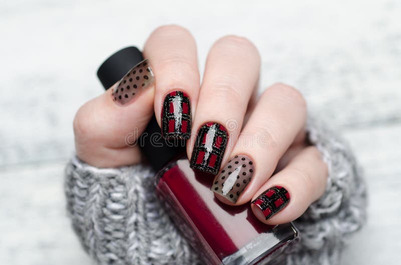 Manicure with a Scottish cage and dots pattern stock photos