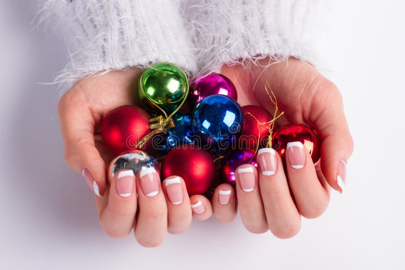 Many colorful Christmas balls in female hands. stock images