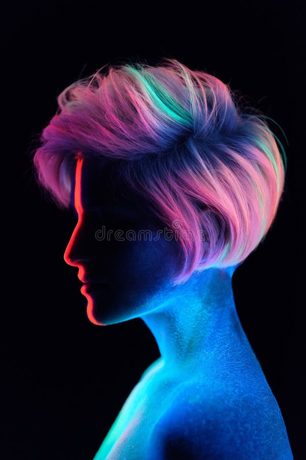 Model young beautiful girl portrait in studio with creative makeup, in neon ultraviolet lamp. Glows in the dark. Hair stock photo