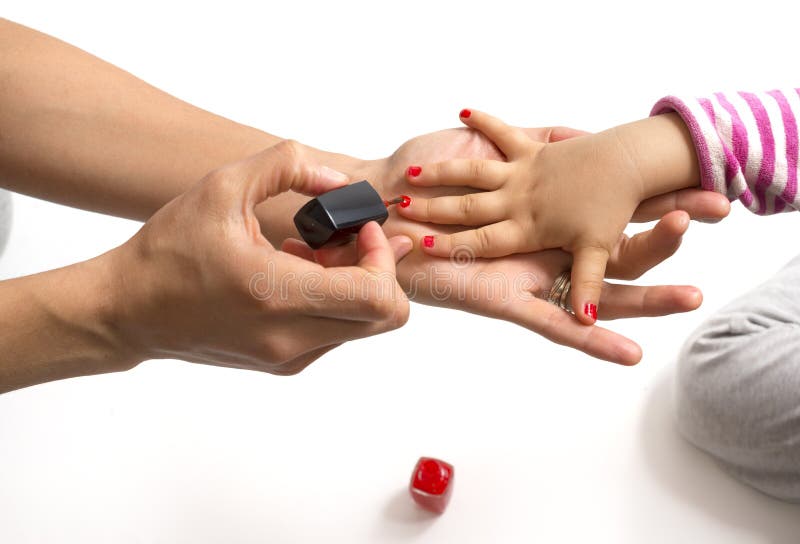 Mother applying nail polish to her little girl isolated stock images