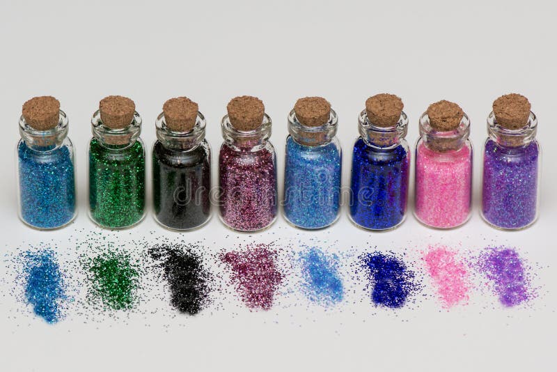 Multicolored glitter for nail manicure and makeup in banks on a white background. macro stock photography