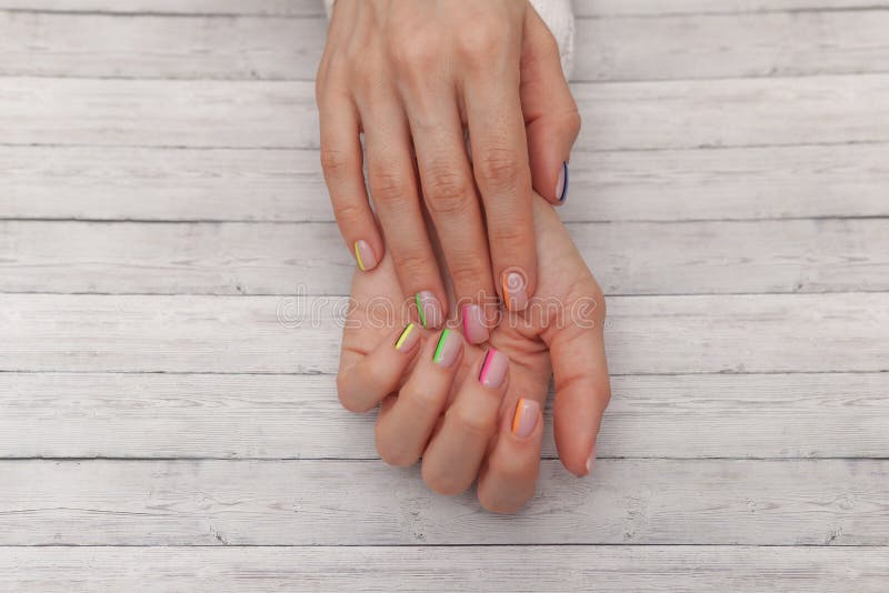 Multicolored modern manicure, nail design. Summer mood, on wooden background. Top view royalty free stock photo