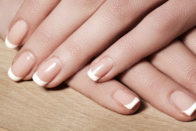 Nails with perfect french manicure. Care for female hands. royalty free stock photography