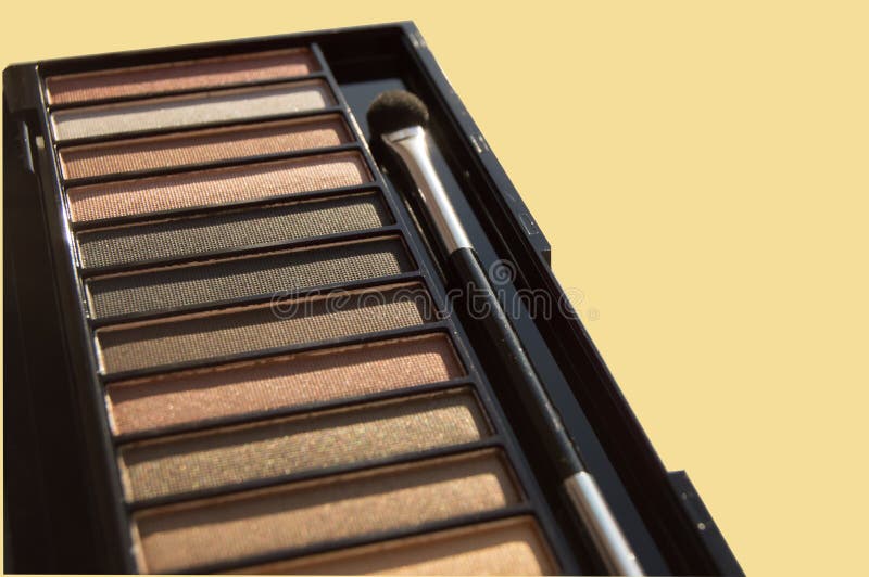 Natural brown Nude eyeshadow palette close-up, with tassel isolated on yellow pastel background stock images