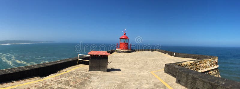 Nazare - lighthouse by the biggest waves in the world. Nazaré is a colorful fishing village in central Portugal. Located almost 80mi north of Lisbon, this stock photos