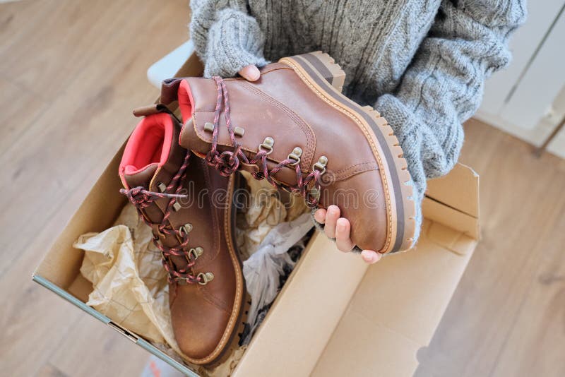 New womens leather brown waterproof winter boots in hands of female. New womens leather brown waterproof hiking winter autumn boots in hands of female, trendy royalty free stock photography