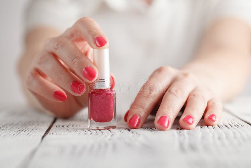 Pair of female hands opening nail polish bottle stock images