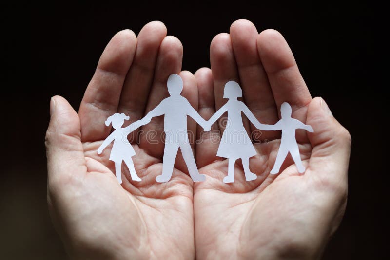 Paper chain family protected in cupped hands stock photos