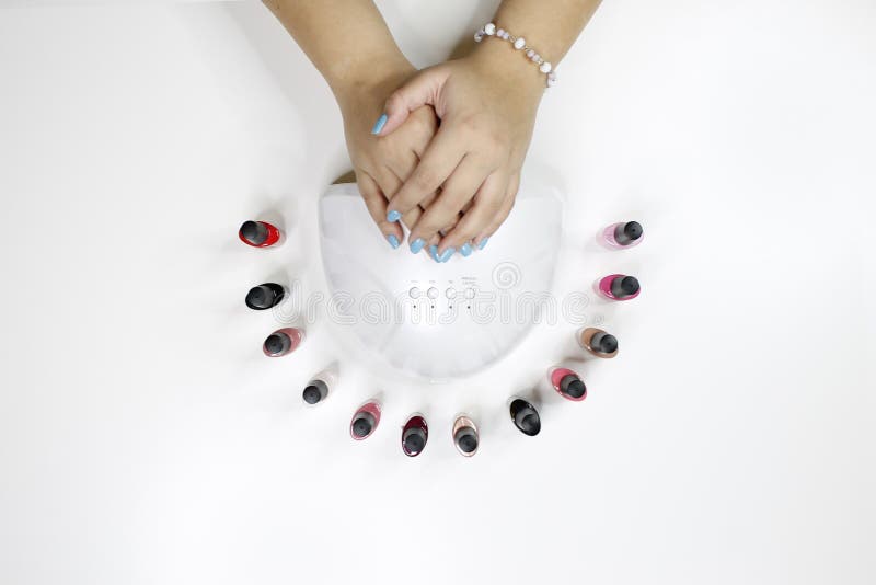 Set of different nail varnishes. Master applies varnish drawing on nails gel in manicure salon royalty free stock image