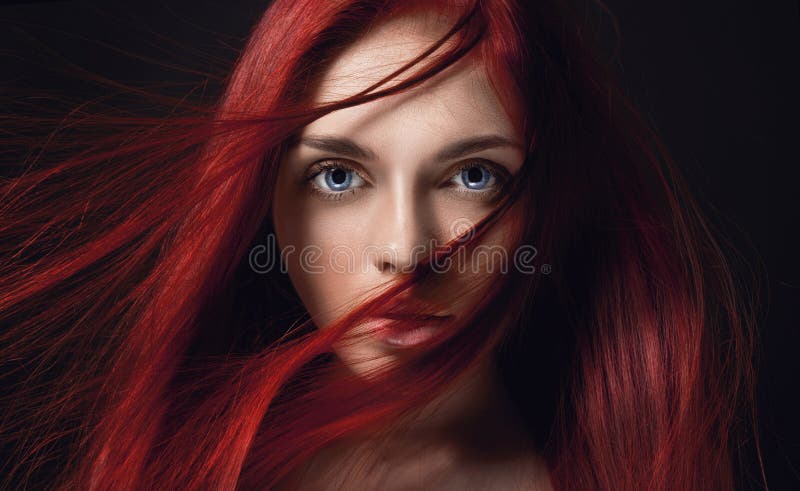 beautiful redhead girl with long hair. Perfect woman portrait on black background. Gorgeous hair and deep big blue eyes stock images