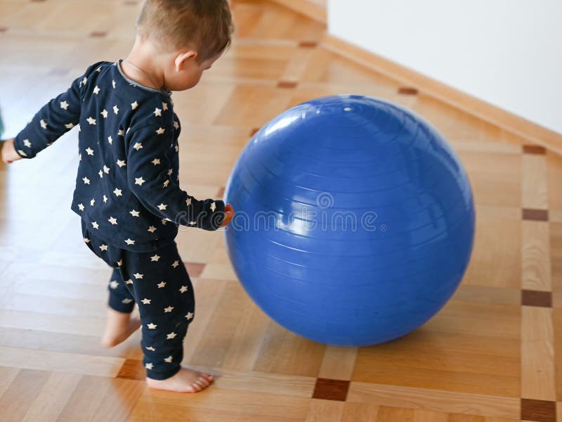 A small child is playing with a ball. Baby banging his head on a ball. High quality photo royalty free stock photos