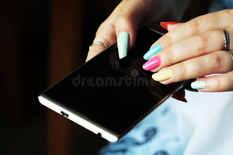 Smartphone in female hands. Beautiful manicure. stock photography